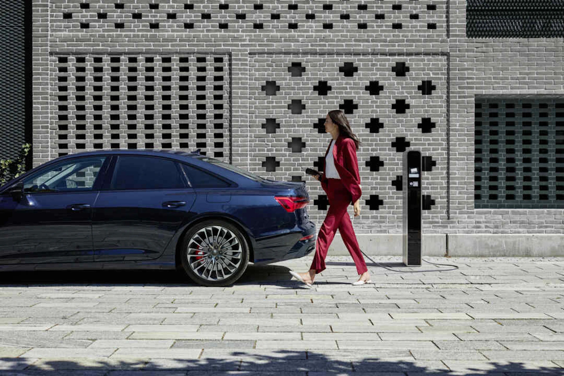 Femme qui est prêt à charge son Audi A8 TFSI e