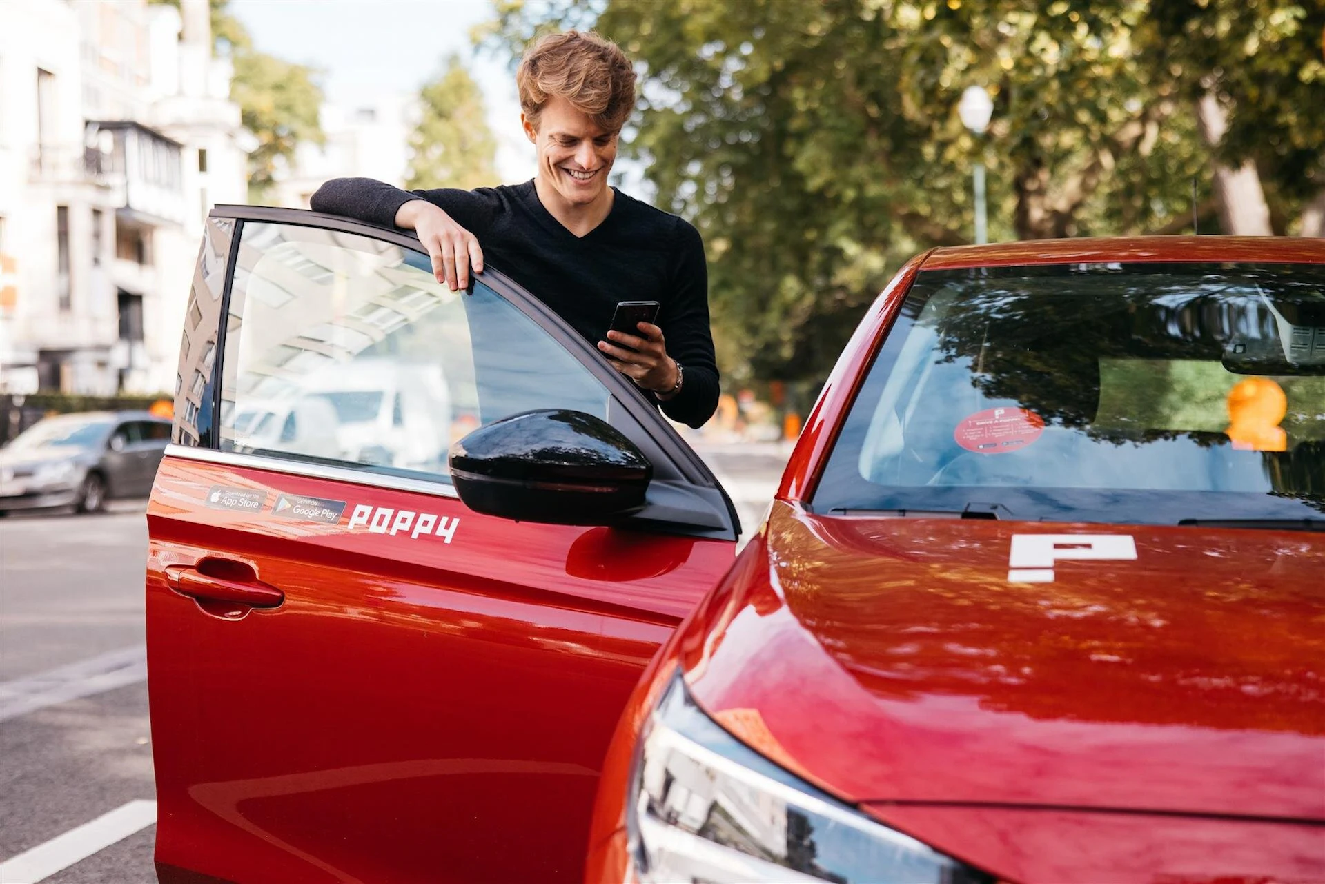 Jongeman naast Poppy deelwagen