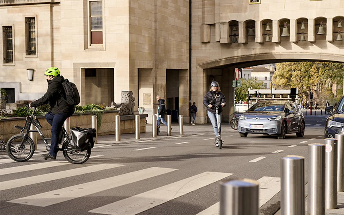 Person on a bicycle, scooter and Volkswagen car in Brussels